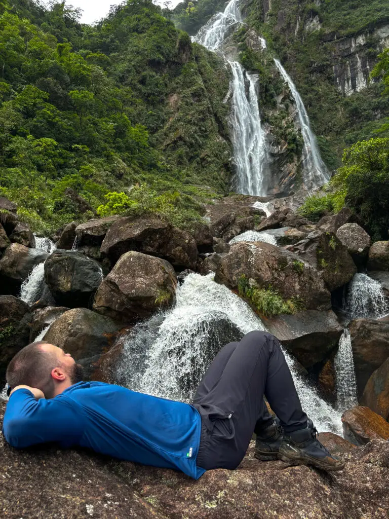 Autor deitado olhando para a imensidão da cachoeira.