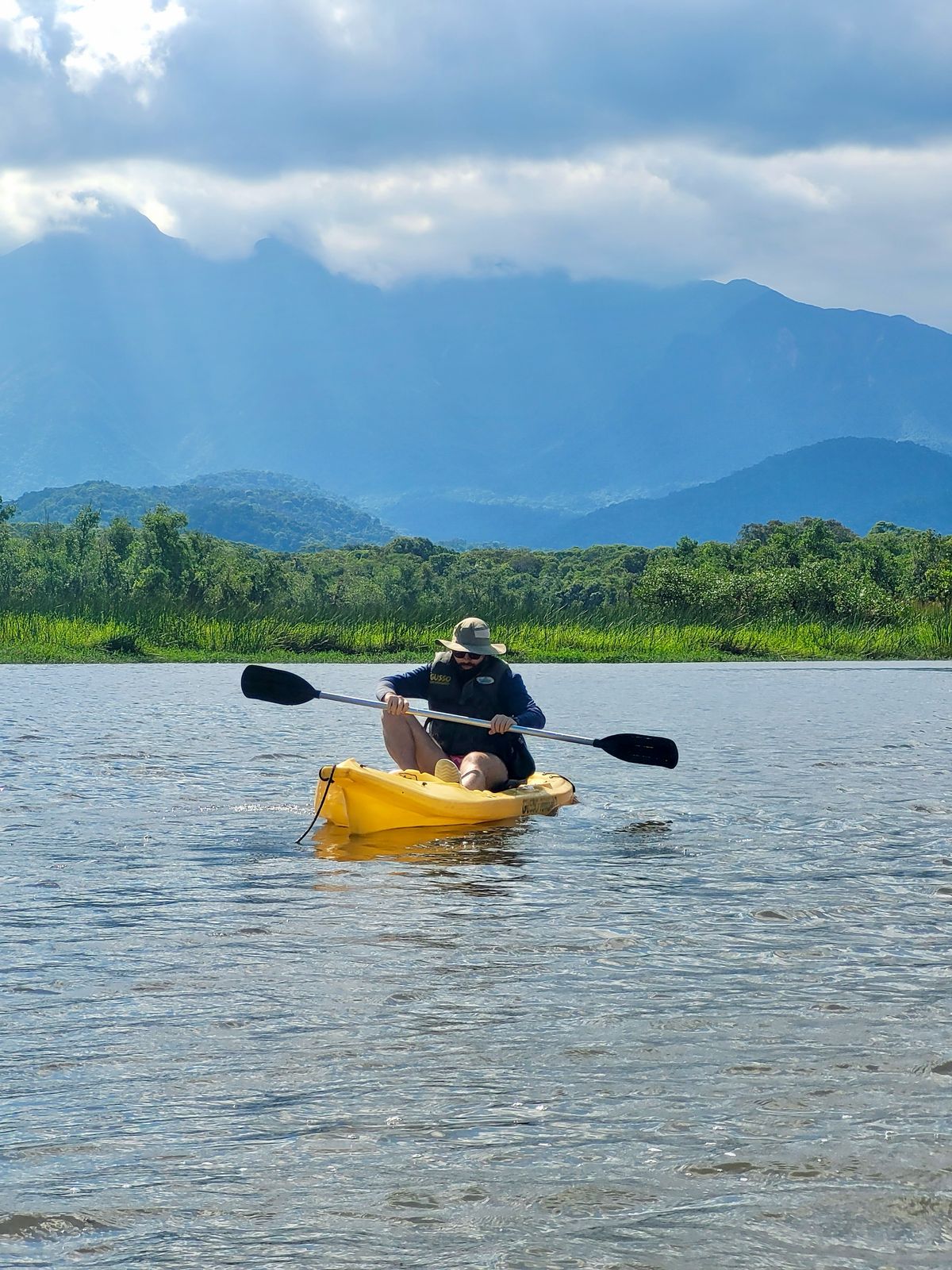 Diego Franzoi em um caiaque amarelo no rio do nunes no Vale do Gigante. De fundo o Pico Paraná.