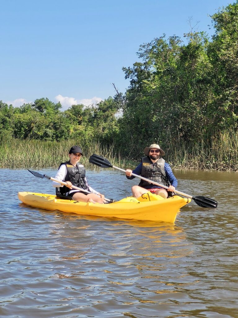 Encontro dos dois caiaques Diego Franzoi e Pamela Schramm posam em seus caiaques amarelos no Rio do Nunes
