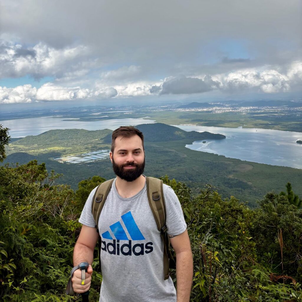 Diego Franzoi de costa para a cidade de Joinville ao fundo.